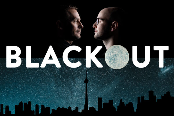 The top half of the frame features dramatic profiles of two white men facing each other in shadow against a black background. The left (Steven Gallagher) has dark features and a moustache, the right is bald and wearing black rimmed glasses (Anton Lipovetsky). Centered in bold text reads, "BLACKOUT", with the O being an image of the moon. The lower half features a background of the Toronto skyline silhouetted against a blue, star filled galaxy sky.