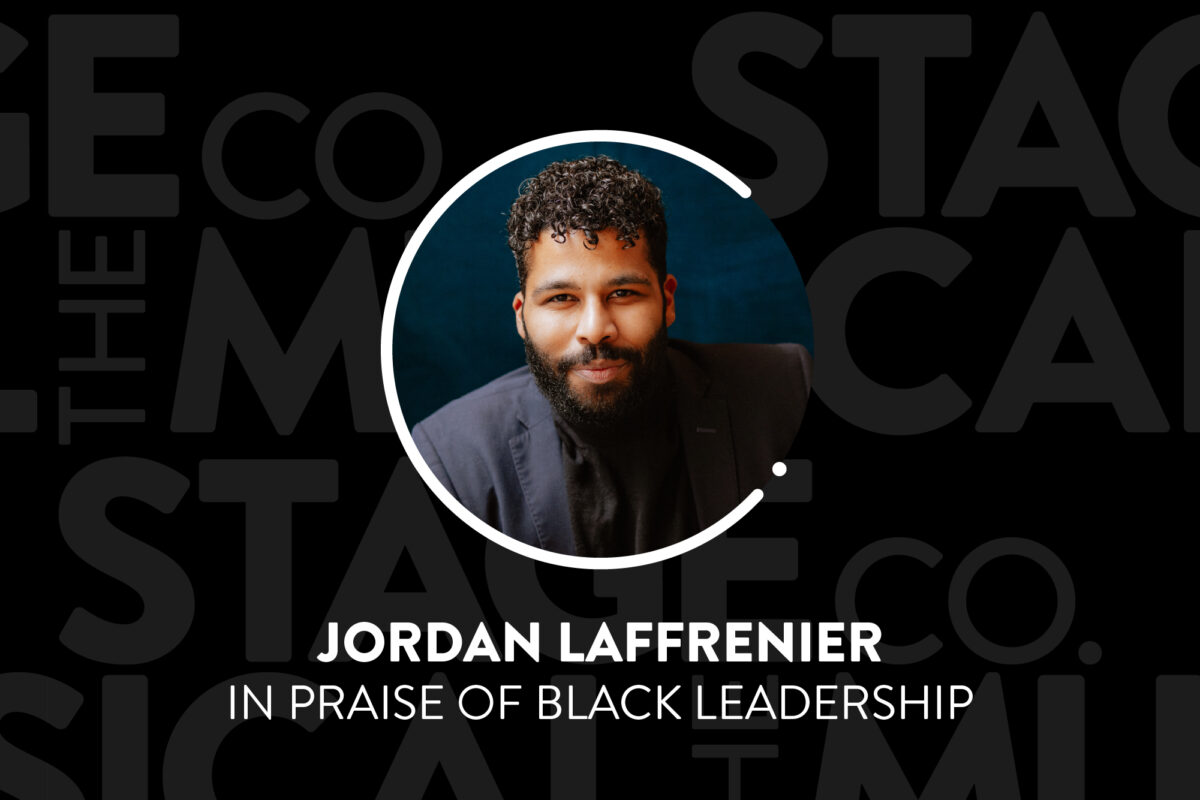 A black background has faded Musical Stage Company logos overlaid. Centered is a circular image of a headshot, with a white 'C' and '.' border. The headshot is Jordan Laffrenier; a Black masc person smiling at the camera & wearing a dark suit. He has black hair with tight curls on top & faded sides, with a full beard. Text underneath reads, “Jordan Laffrenier / In Praise of Black Leadership.”