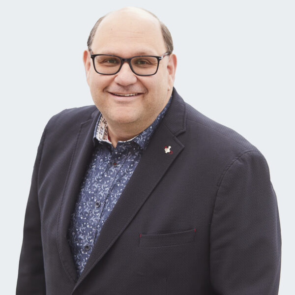 Headshot image of Michael Rubinoff. Michael is wearing glasses, a blue collared shirt and a black suit jacket.